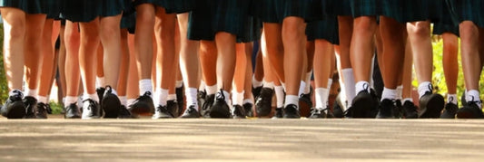 A group of children walking together, each wearing school socks over their shoes.