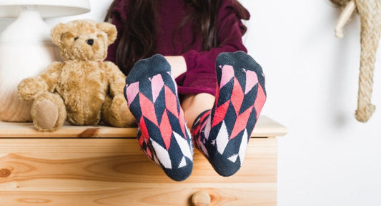 Close-up of kids' socks while putting on sneakers before playing outside